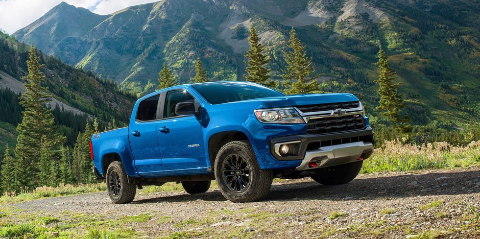 A blue 2022 Chevrolet Colorado parked on a mountain with a mountain range visible in the background.