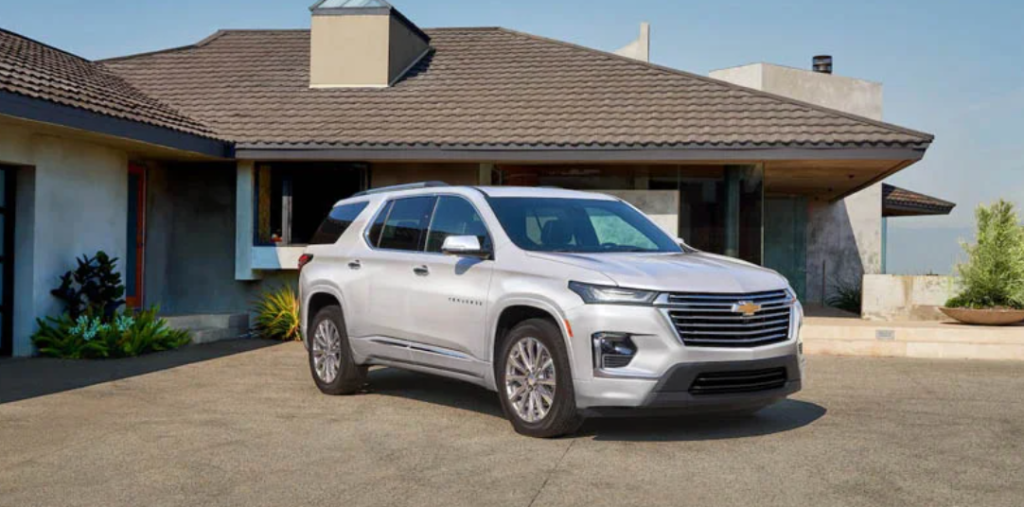 A white 2022 Chevy Traverse parked in front of a house on the driveway.