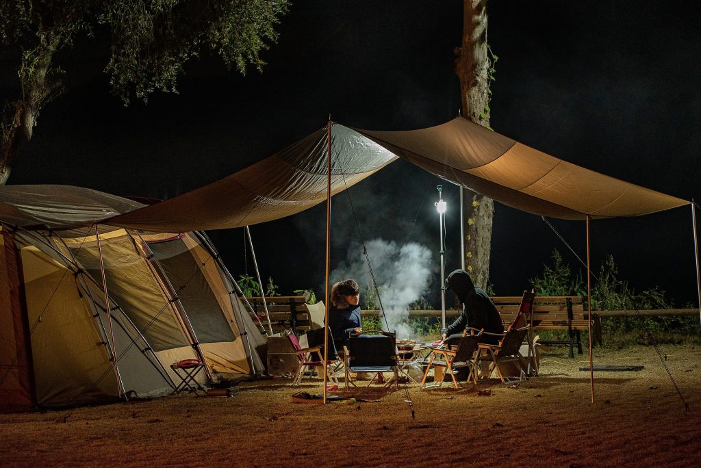 People camping under a tent.