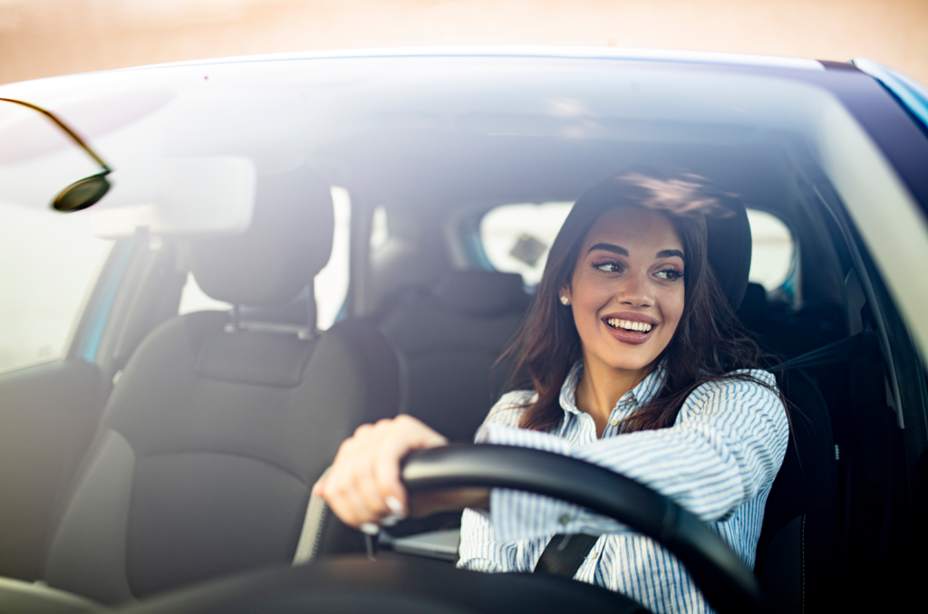 A woman smiling and driving.