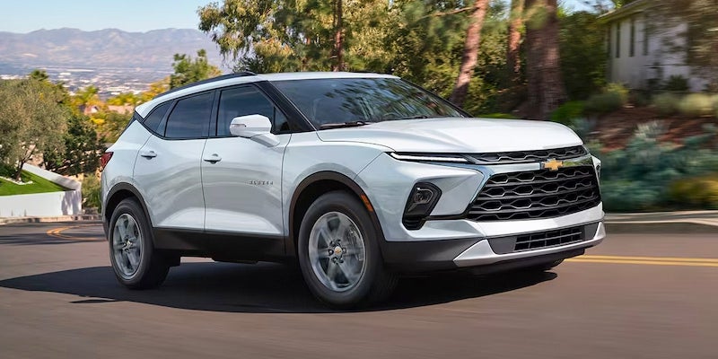 A white 2024 Chevrolet Blazer driving on the road.