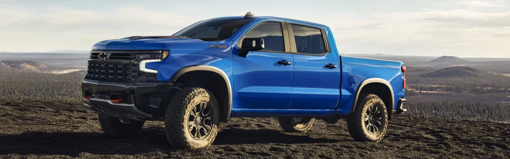 Blue Chevrolet Silverado off-road truck showcasing lifted stance, all-terrain tires, and strong outdoor capability.