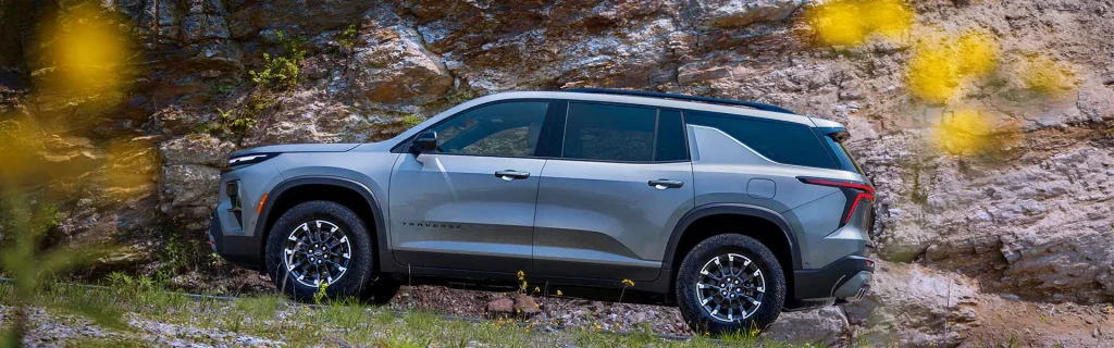 Side view of a gray Chevrolet Traverse showing rugged stance and outdoor driving capability.