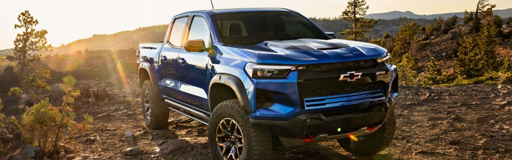 Blue Chevrolet Colorado ZR2 pickup truck driving on a rocky mountain trail
